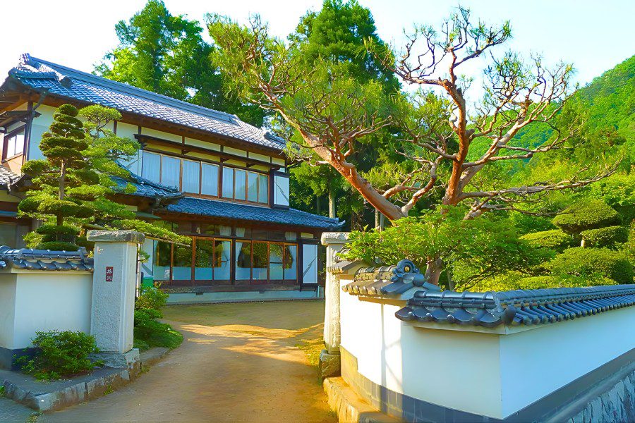 Biệt thự vườn phong cách truyền thống (Ryokan), mái ngói cong vút ở đầu đao, tường trắng lộ khung gỗ (timber framing) và vườn cây Bonsai điểm nhấn