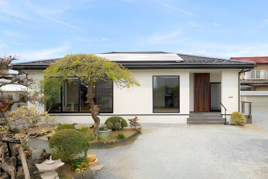 Nhà cấp 4 kiểu Nhật phong cách hiện đại, tường trắng, cửa trượt kính, sân đá sỏi và kết hợp trang trí nhiều cây cảnh