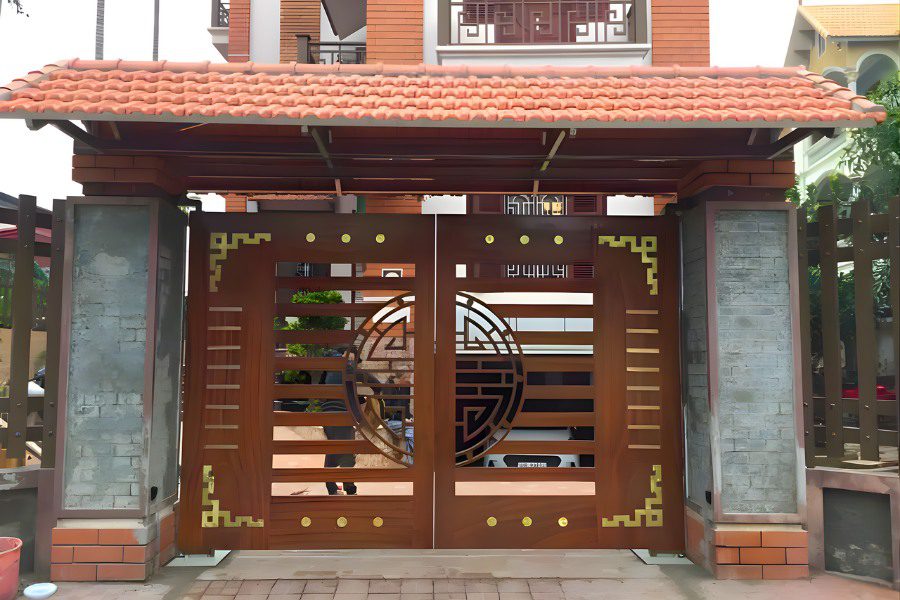 Cổng giả gỗ 2 cánh màu nâu đỏ họa tiết chữ Thọ hình tròn.