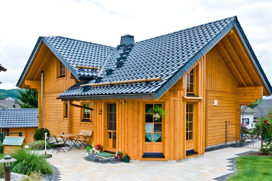 Mẫu nhà gỗ cấp 4 mái thái xanh đen kết hợp vách gỗ sáng màu.
