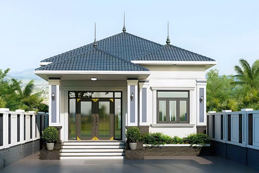 Mẫu nhà cấp 4 mái Nhật đơn giản, mặt tiền trắng và xanh xám, bao quanh là hàng rào và cây xanh.